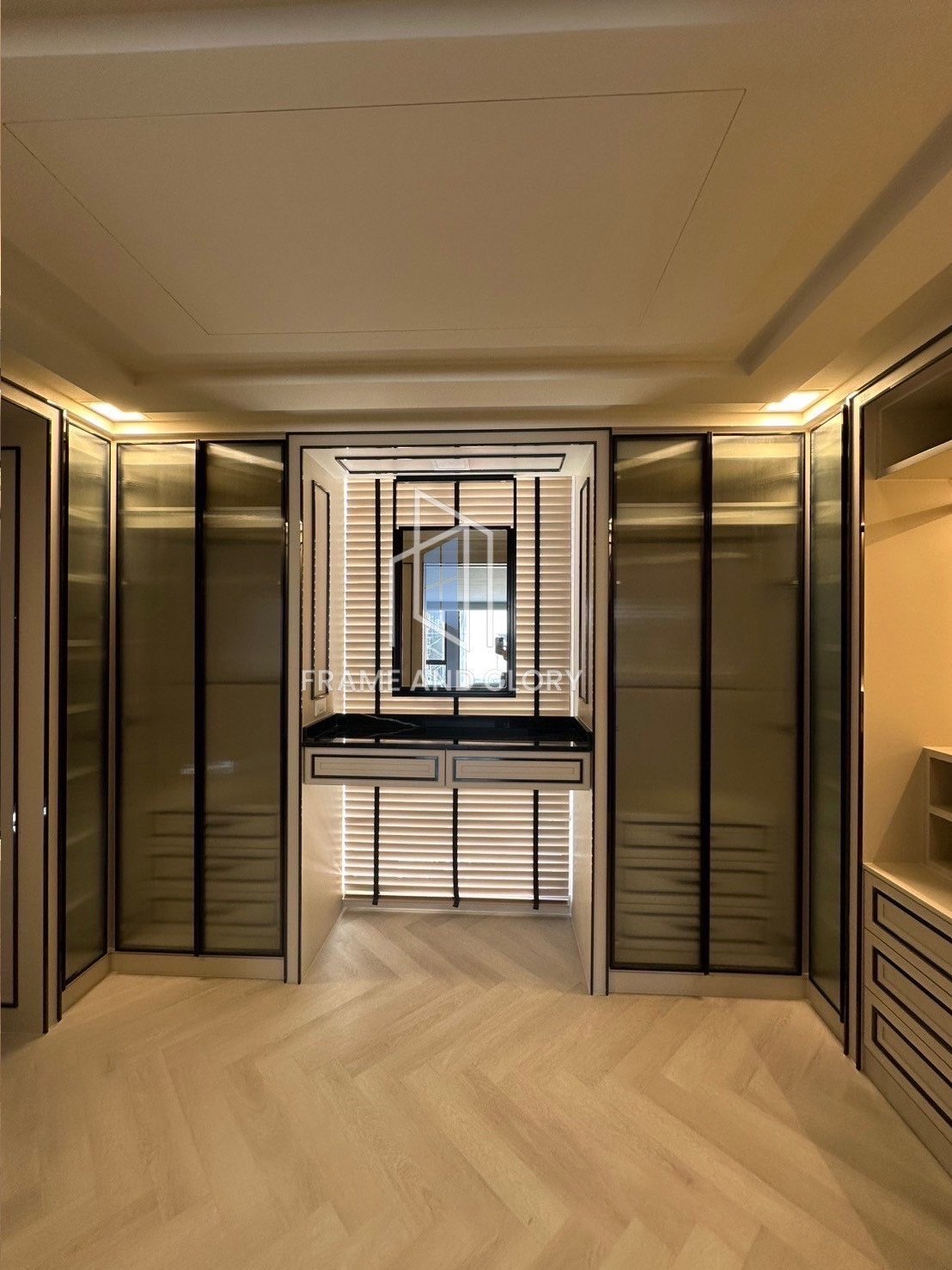 Luxury walk-in closet with black framed glass doors