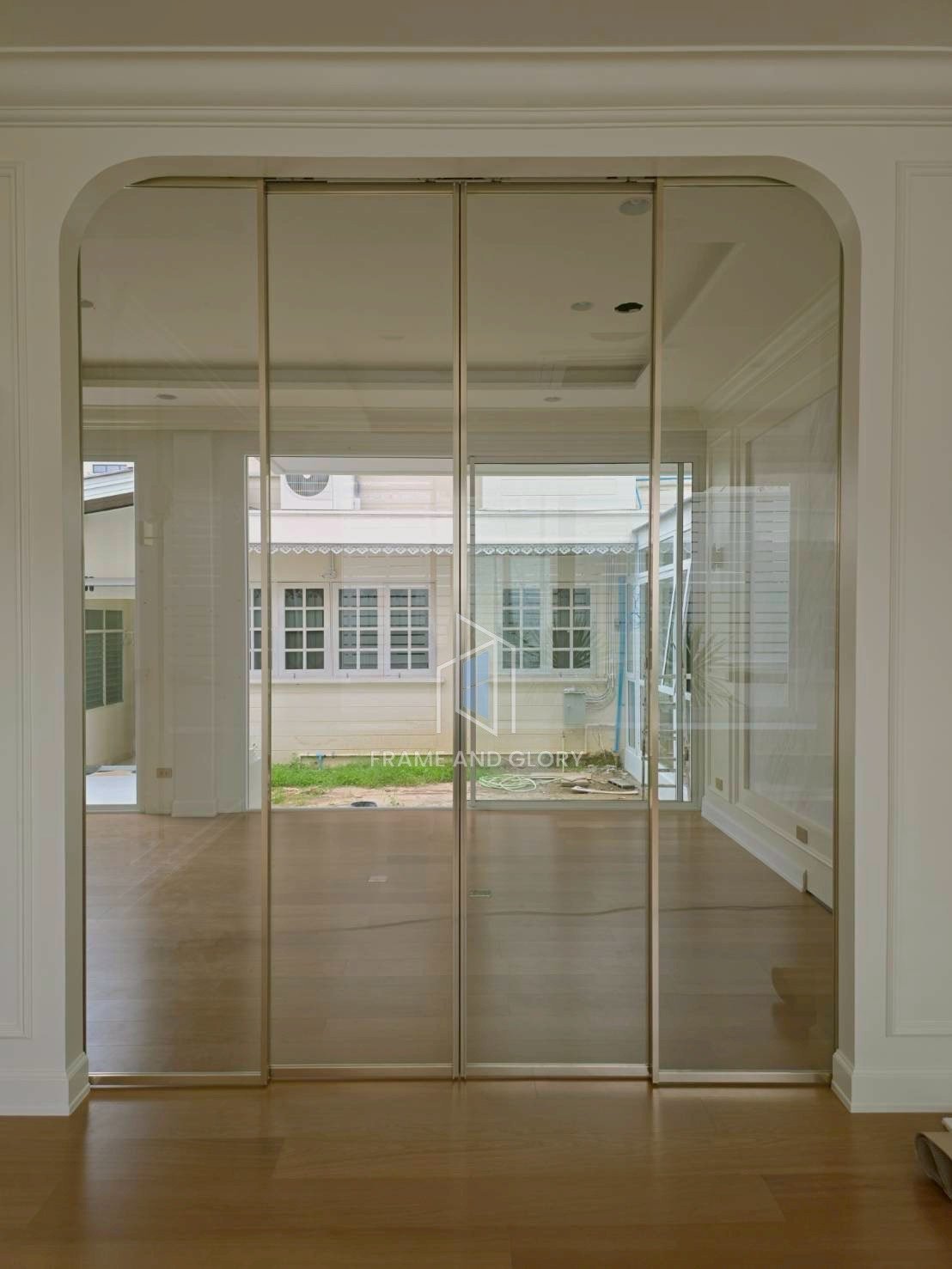 Glass sliding doors opening to sunroom with garden view
